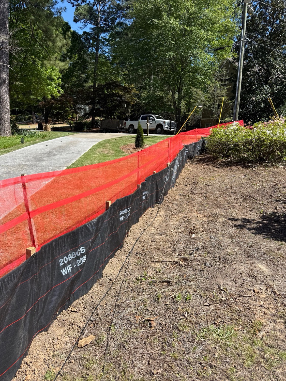 Reinforced super silt fence installed along a graded residential lot for sediment control